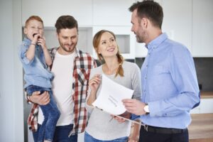 Family and real estate agent talking in new apartment